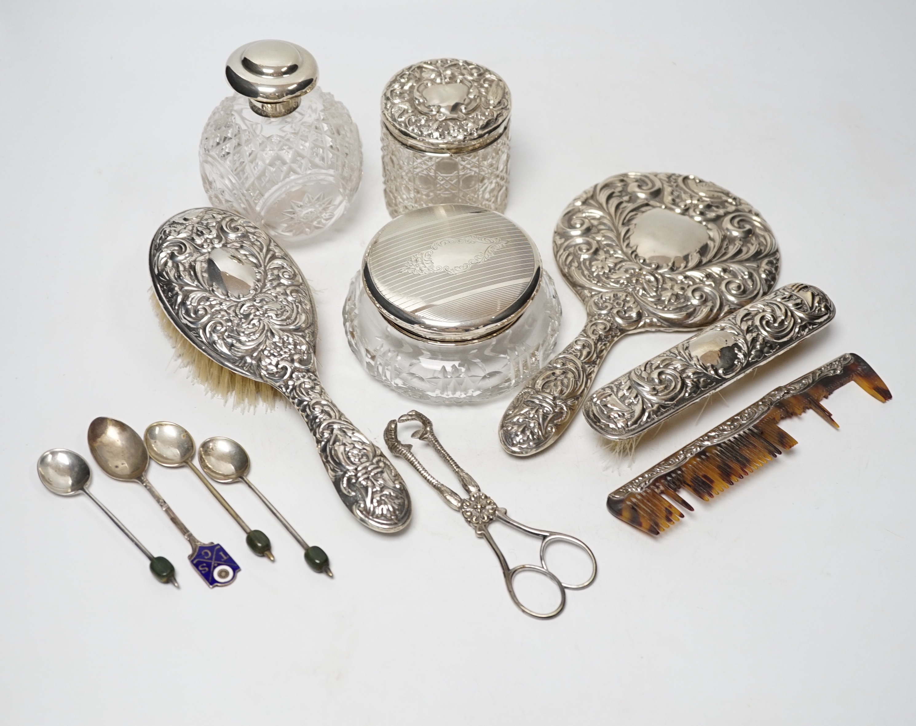 Seven assorted silver mounted glass scent bottles or toilet jars, and a repousse silver backed four piece dressing table set (a.f.) and other items including plated coffee spoons, place setting holders, etc.